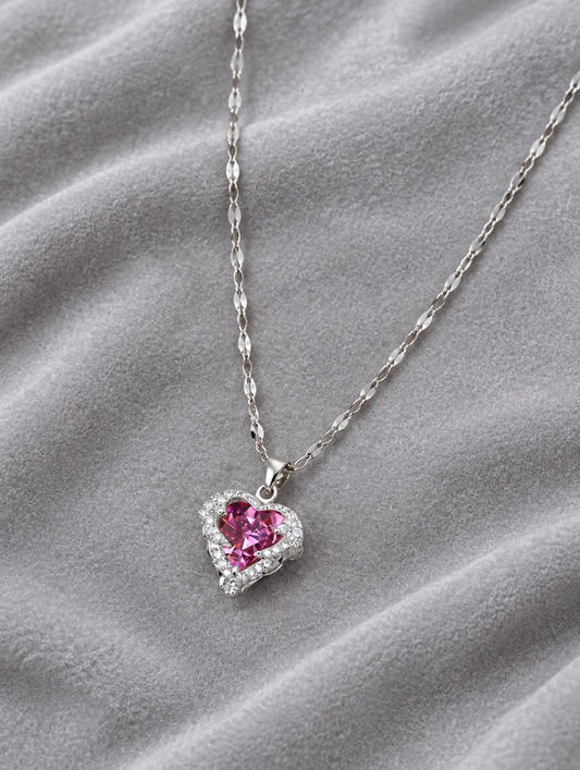 Pink heart pendant necklace lying on soft grey velvet