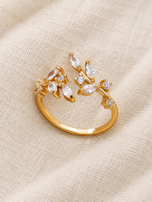 Gold leaf branch zirconia ring resting on a soft textured surface