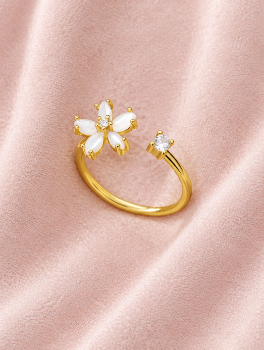 Gold flower zirconia ring resting on a soft textured surface