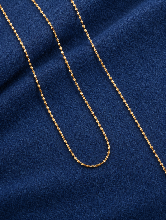 Gold sparkle chain necklace lying on navy blue fabric