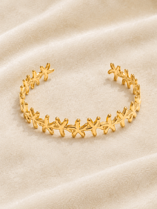 Gold starfish cuff bracelet on cream velvet