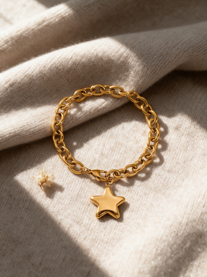 Gold chain bracelet with star charm on a beige knit