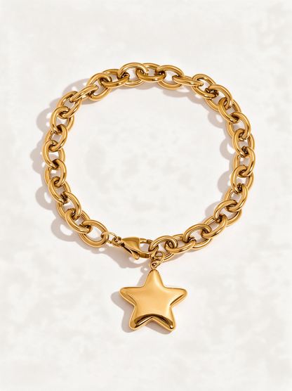 Chunky gold cable chain bracelet with puffy star charm on a neutral background