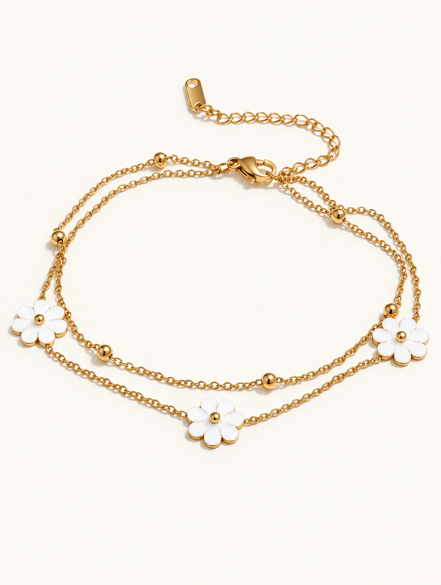 Gold-tone double chain anklet with three white flower charms on a neutral background