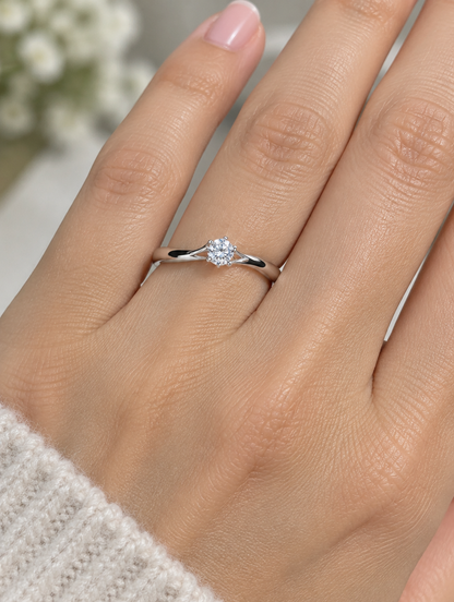 Woman wearing a silver solitaire zirconia ring on her finger