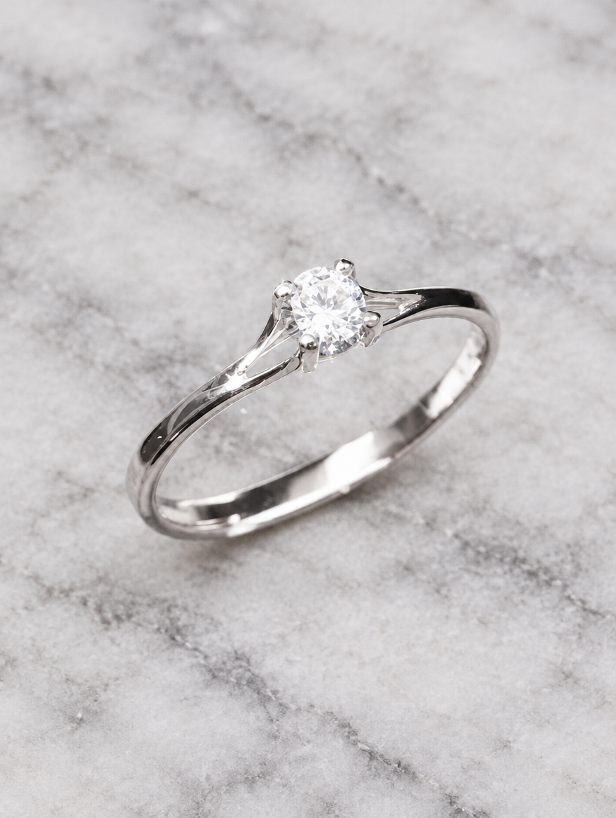 Silver solitaire zirconia ring resting on a soft textured surface
