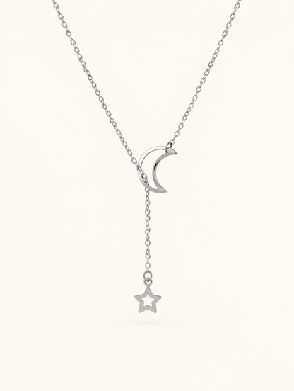 Silver-tone moon and star lariat necklace on a neutral background