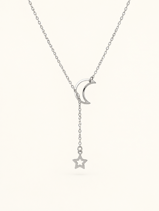 Silver-tone moon and star lariat necklace on a neutral background