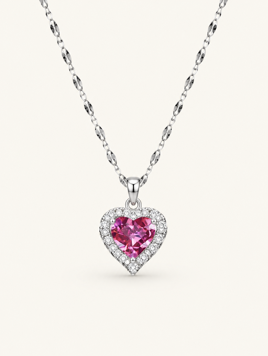 Silver-tone necklace with a pink crystal heart pendant on a neutral background
