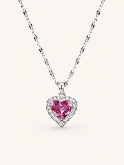 Silver-tone necklace with a pink crystal heart pendant on a neutral background