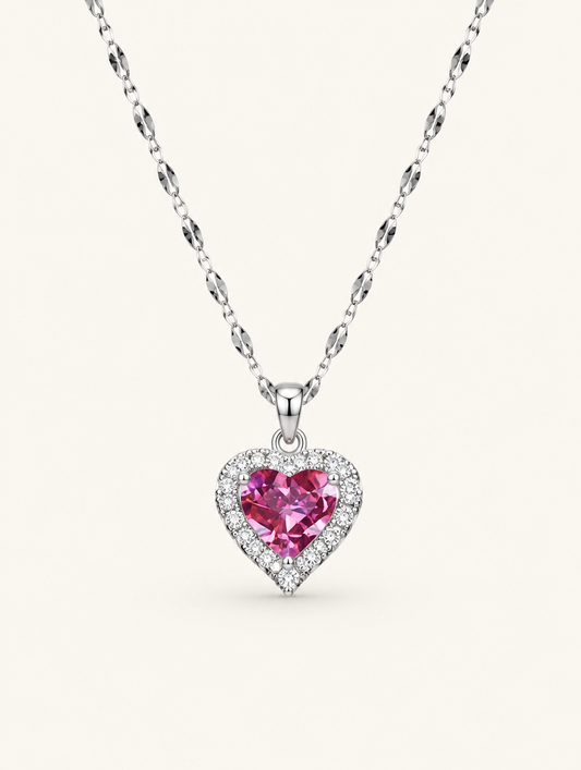 Silver-tone necklace with a pink crystal heart pendant on a neutral background