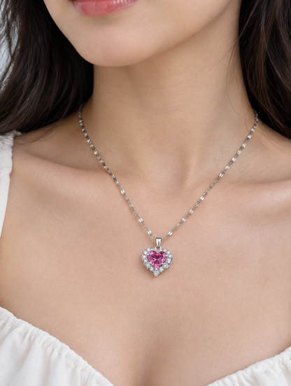 Woman wearing a silver necklace with a pink crystal heart pendant