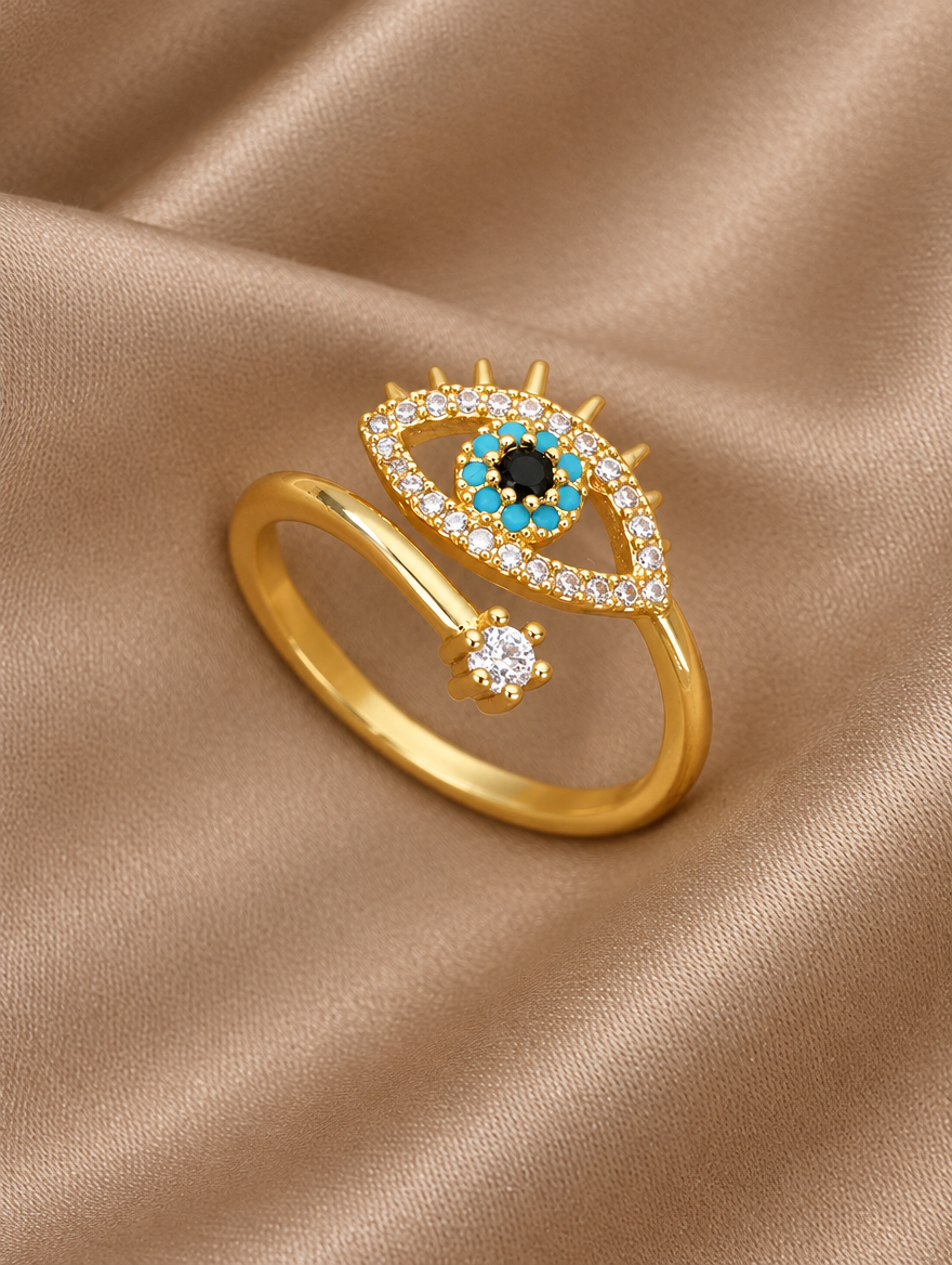 Gold evil eye zirconia ring resting on a soft textured surface