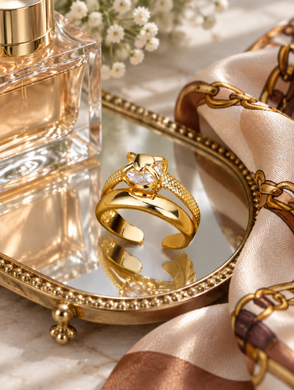 Gold double band zirconia ring in a small dish with styling props