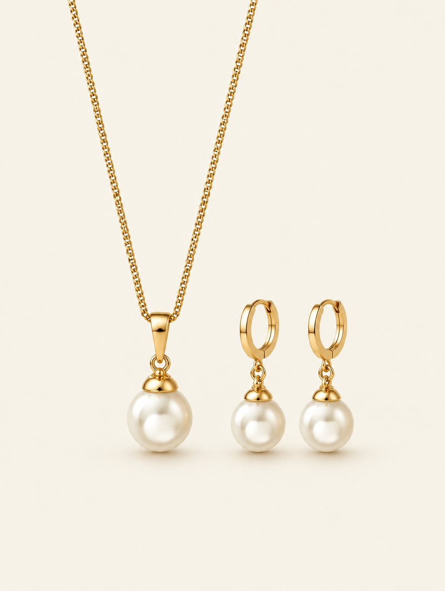 Gold pearl pendant necklace and drop hoop earrings set on a neutral background