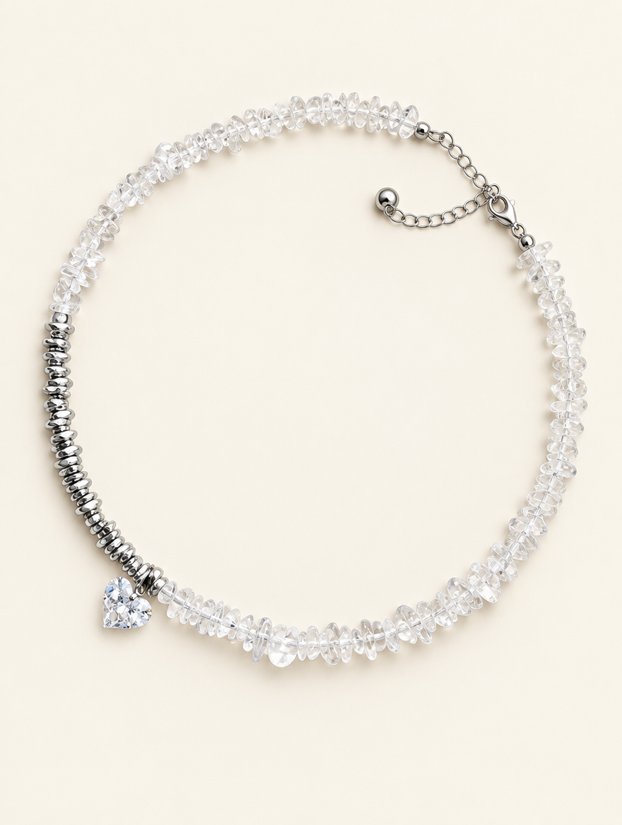 Clear chip bead choker necklace with a heart charm and silver-tone spacer beads on a neutral background