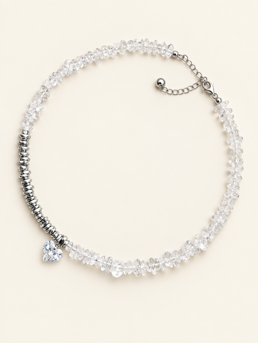 Clear chip bead choker necklace with a heart charm and silver-tone spacer beads on a neutral background
