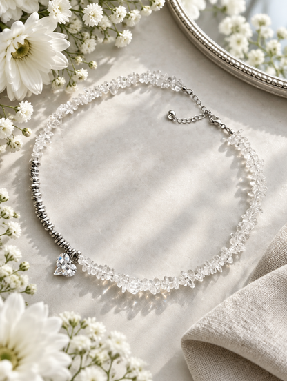Clear chip bead necklace with white flowers, a small mirror and folded linen