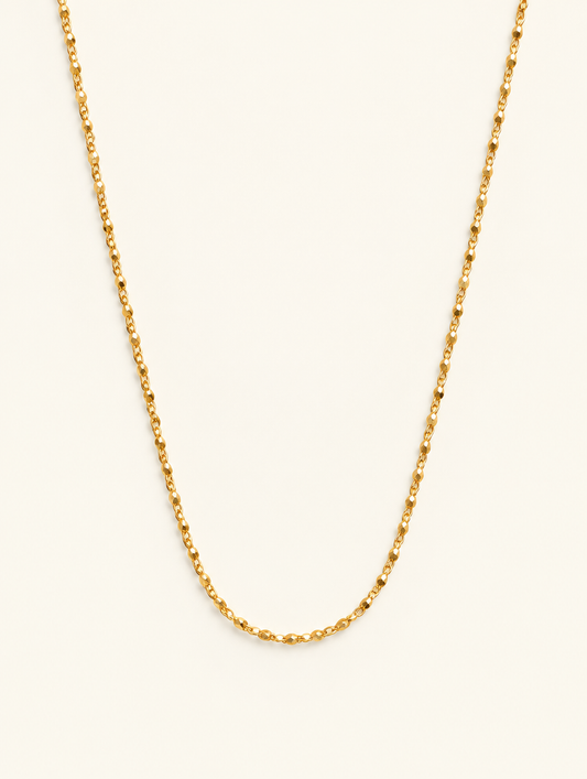 Fine gold-tone sparkle cable chain necklace on a neutral background