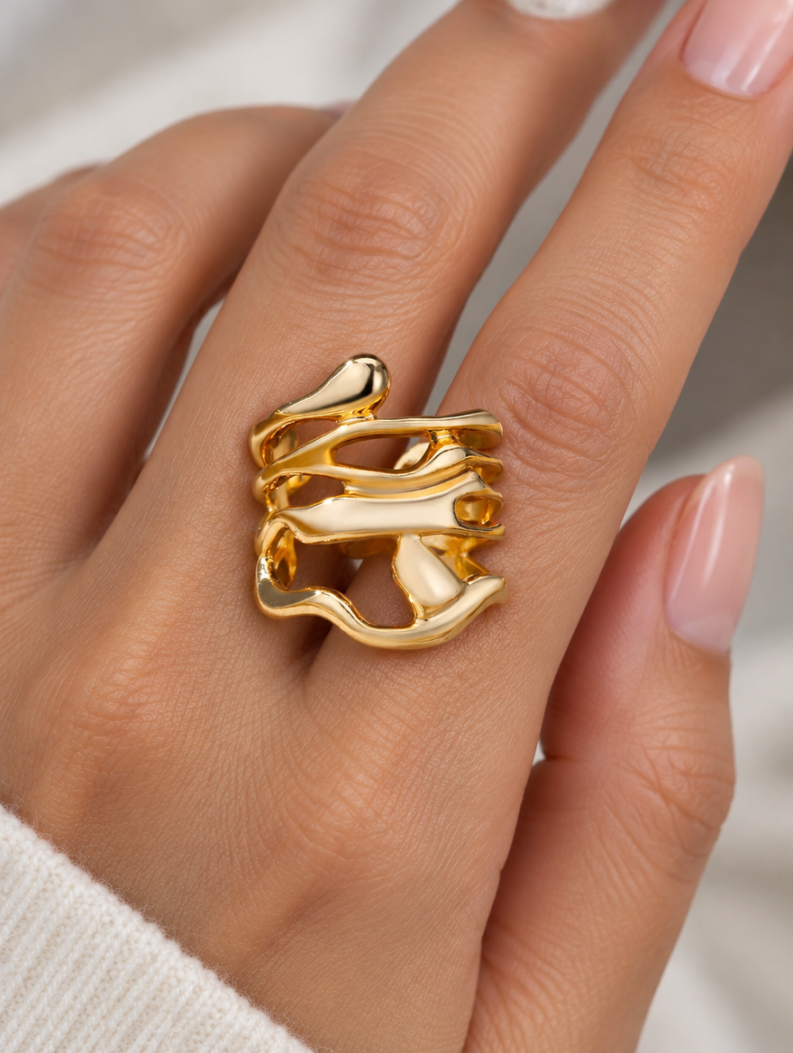 Woman wearing a wide gold wavy open ring on her finger