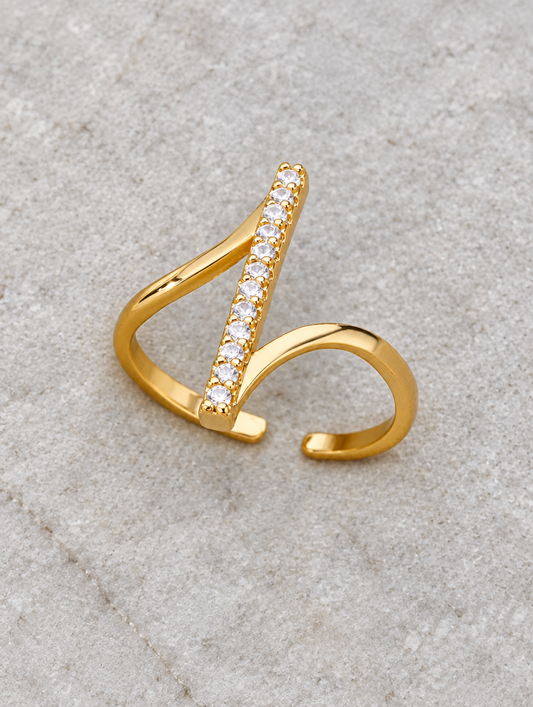 Gold bar zirconia wrap ring resting on a soft textured surface