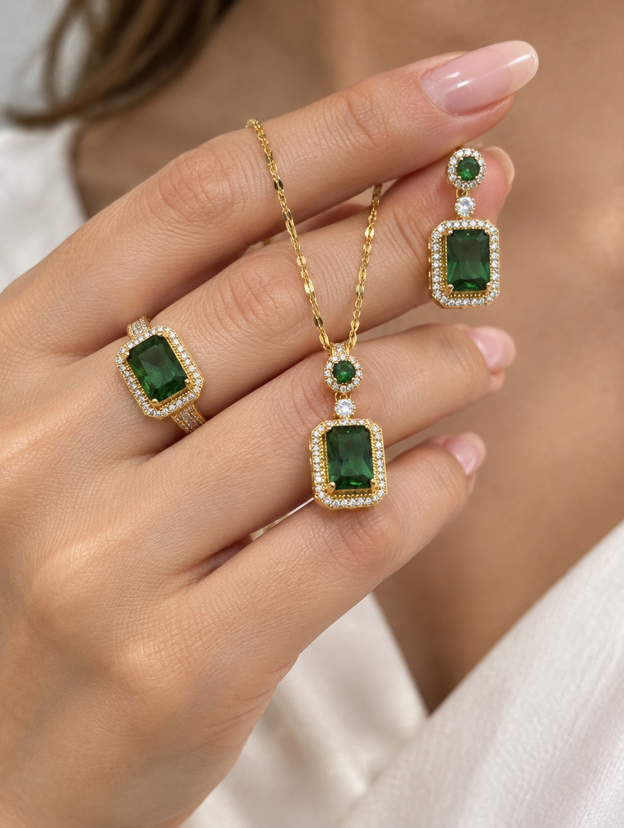 Hand wearing a green crystal ring and holding a matching necklace and earring