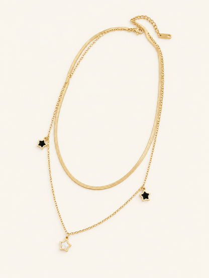 Gold-tone double layer necklace with small star charms on a neutral background