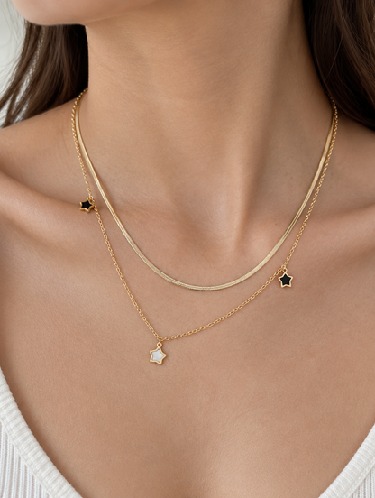 Woman wearing a gold-tone double layer necklace with small star charms