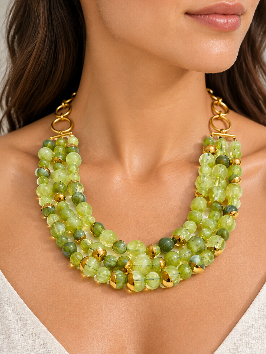 Woman wearing a chunky green beaded collar necklace with gold accents
