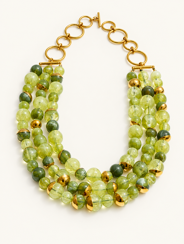 Green multi-strand beaded collar necklace with gold-tone accents on a neutral background