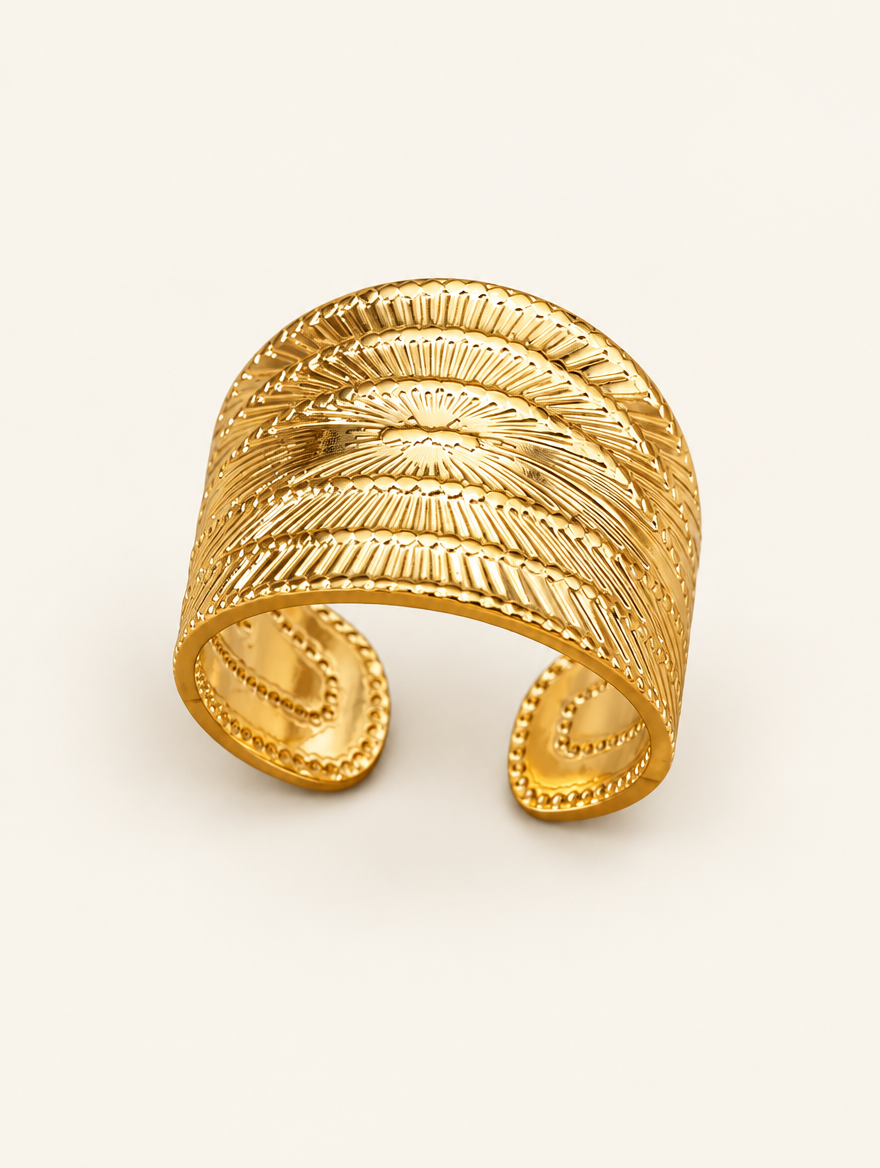 Wide gold ribbed open ring on a neutral background