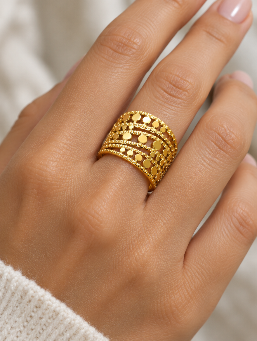 Woman wearing a wide gold disc texture open ring on her finger