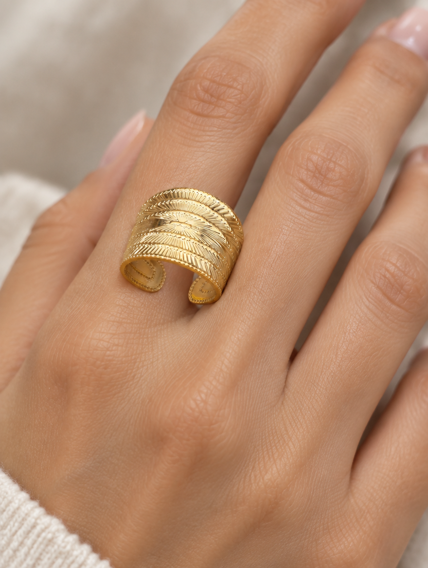 Woman wearing a wide gold ribbed open ring on her finger