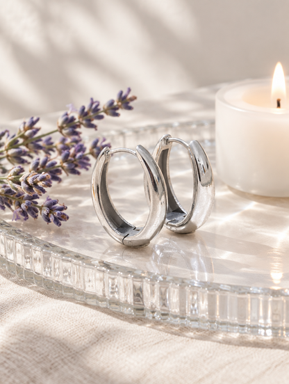 316l steel silver huggie hoop earrings in a styled still life with props