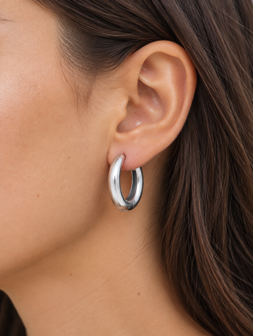 Woman wearing a 316l steel silver huggie hoop earring