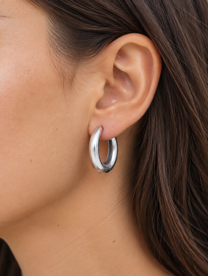 Woman wearing a 316l steel silver huggie hoop earring