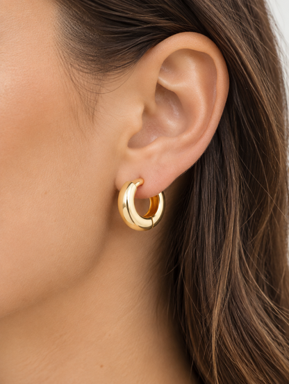 Woman wearing a gold-plated chunky huggie hoop earring