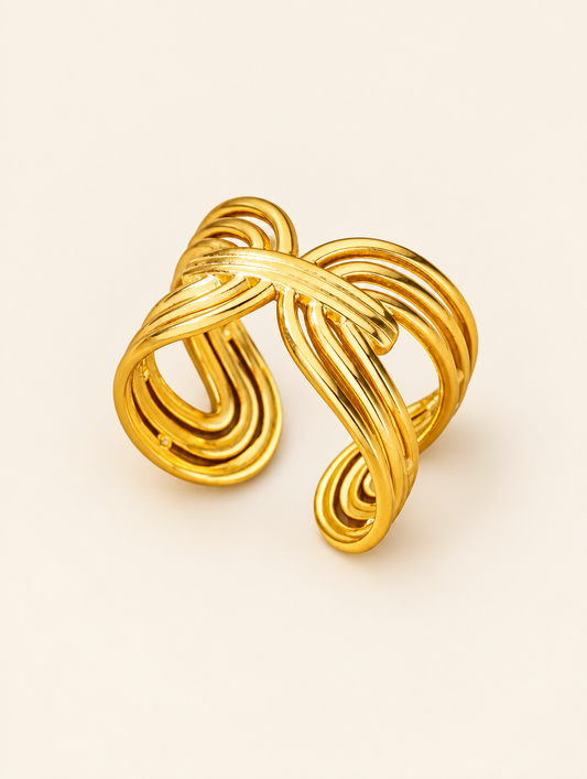 Gold twisted ribbon open ring on a neutral background