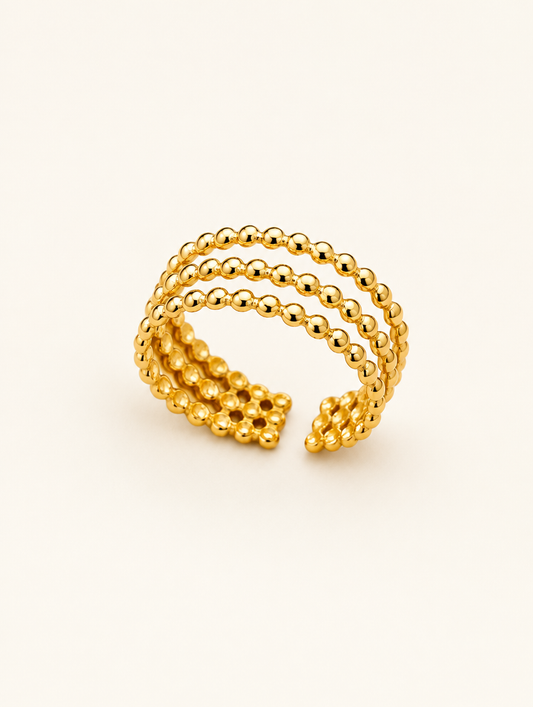 Gold triple row beaded open ring on a neutral background
