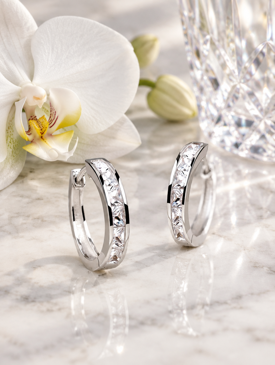 Silver princess-cut zirconia hoop earrings in a styled still life with props