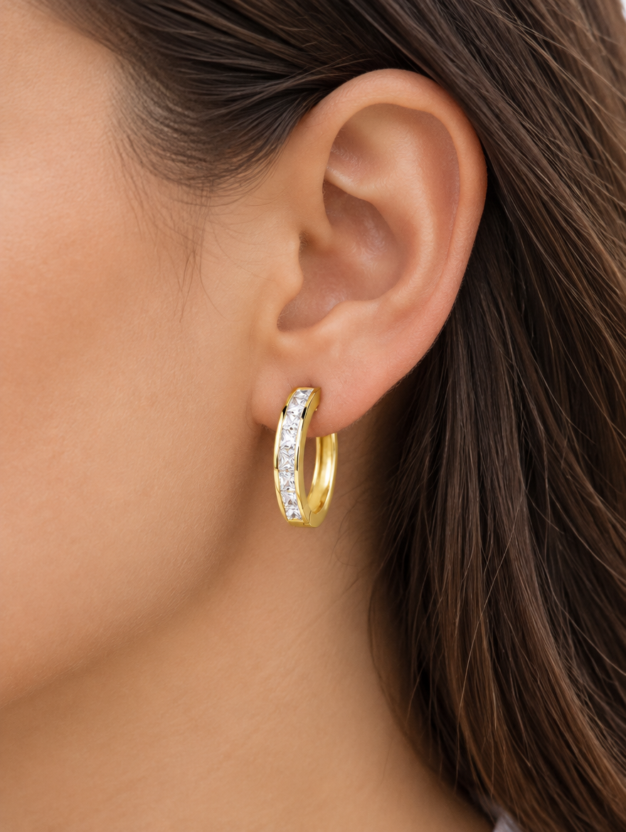 Woman wearing a gold princess-cut zirconia hoop earring