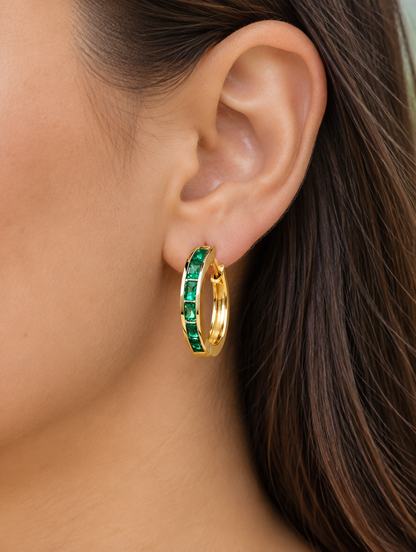 Woman wearing a gold emerald-green zirconia hoop earring