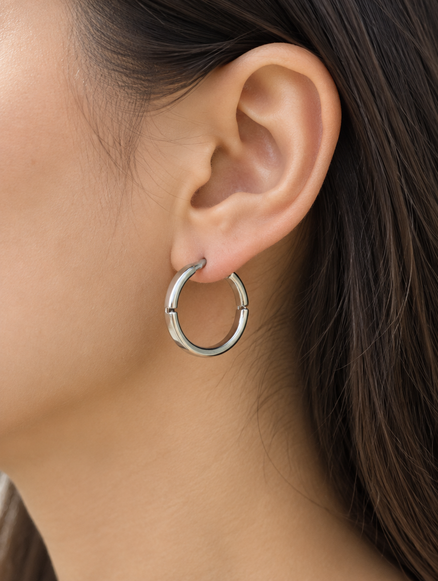 Woman wearing a classic silver-tone round hoop earring