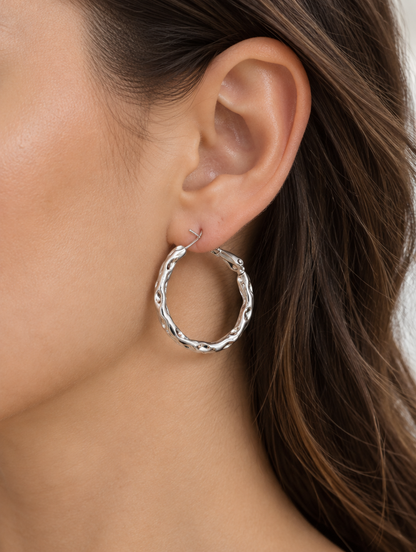 Woman wearing a silver-tone textured twisted hoop earring