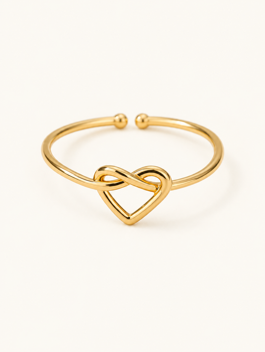 Gold open heart ring on a neutral background
