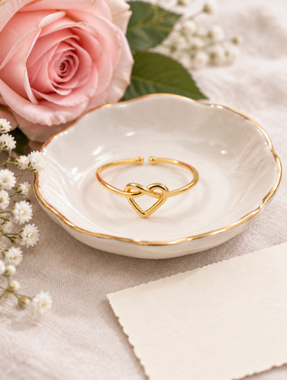 Gold open heart ring in a small dish with styling props