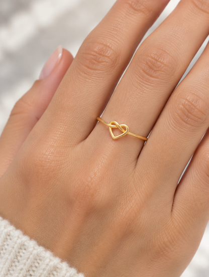 Woman wearing a gold open heart ring on her finger