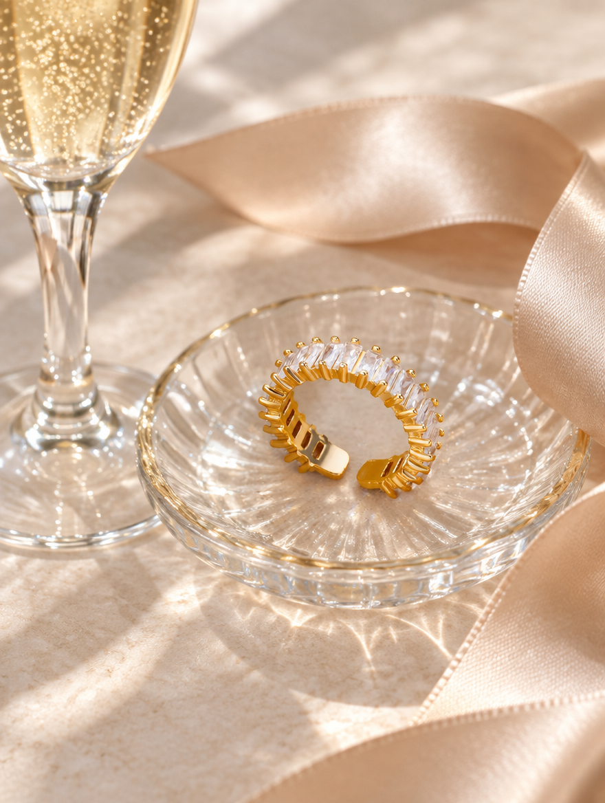 Gold baguette clear stone ring in a small dish with styling props