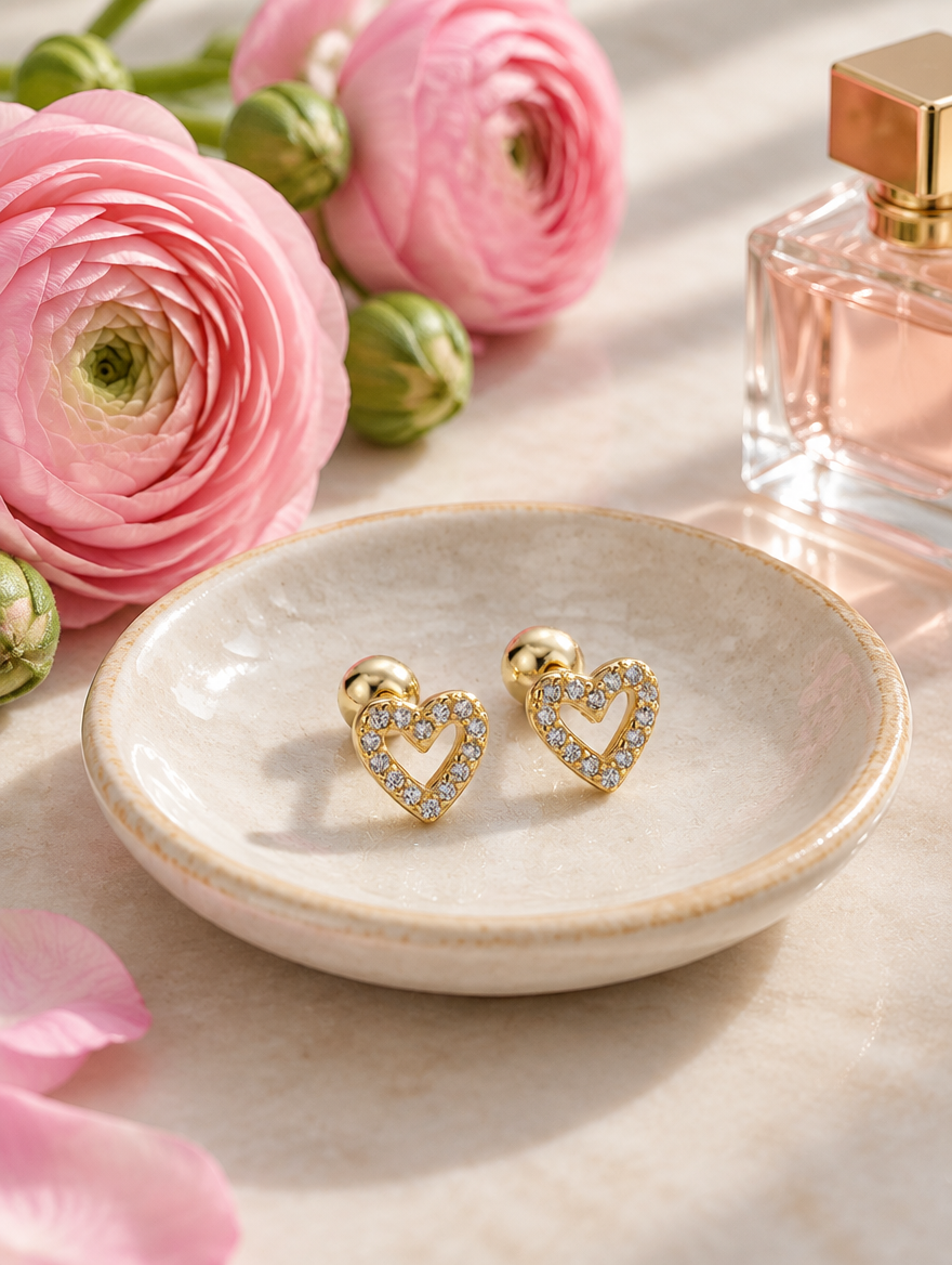 Gold open heart stud earrings in a styled still life with props