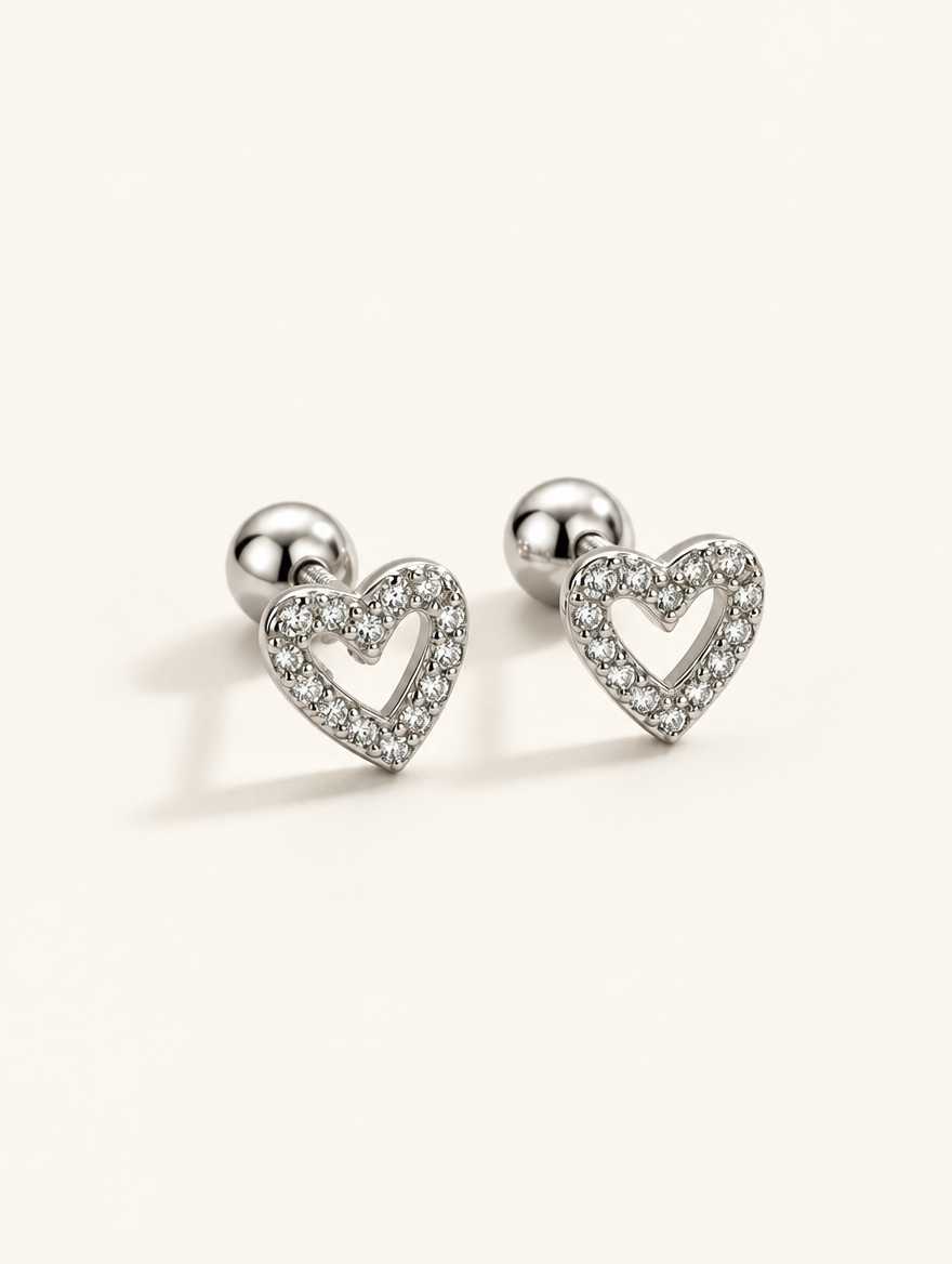 Pair of silver open heart stud earrings on a warm off-white background